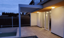 Šedá venkovní pergola kotvená k domu  